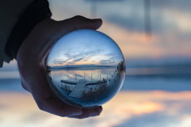 Doğayı cam bir top ile görmek, yaz günbatımı zamanı. Kristal cam küreyi arka planda tutarken yansımaları vardı.