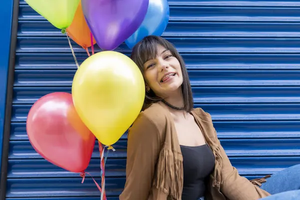 Young woman holding a bunch of balloons