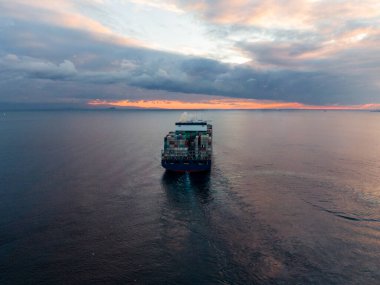 Açık okyanusta seyahat eden büyük, dolu konteynır gemisinin havadan görüntüsü.