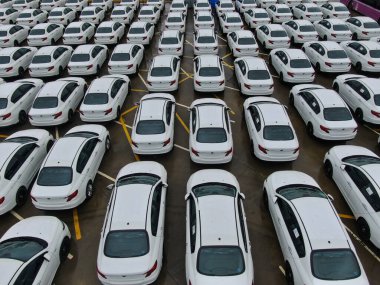 Birçok yeni beyaz arabanın havadan görüntüsü fabrika otoparkına park edilmiştir.
