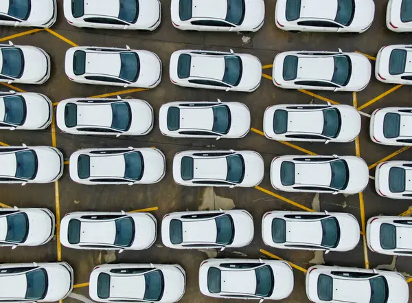 Birçok yeni beyaz arabanın havadan görüntüsü fabrika otoparkına park edilmiştir.