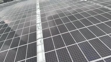 Elektrik santralindeki güneş panelleri. Fotovoltaik panellerle güneş enerjisini tarım arazilerindeki yeşil enerji için elektriğe dönüştüren bir güneş çiftliğinin üzerinde uçmak