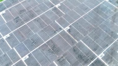 Elektrik santralindeki güneş panelleri. Fotovoltaik panellerle güneş enerjisini tarım arazilerindeki yeşil enerji için elektriğe dönüştüren bir güneş çiftliğinin üzerinde uçmak