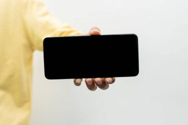 Adam elinde boş ekranlı akıllı telefonu tutuyor.