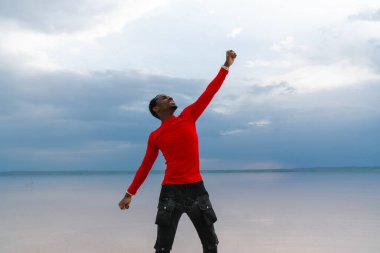 Genç Afro-Amerikan bir adam, deniz altyapısı karşısında duruyor.