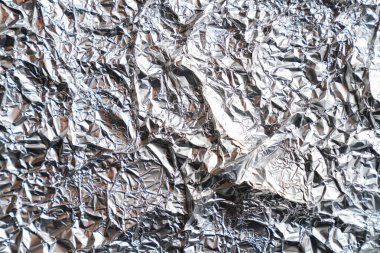 Parlak buruşuk yüzeyi olan gümüş folyo arka plan doku arkaplanı