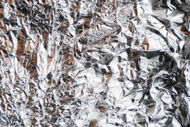 Parlak buruşuk yüzeyi olan gümüş folyo arka plan doku arkaplanı