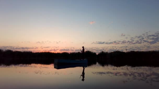 地元の漁師が早朝に川でボートを漕いでいる 日の出に穏やかな海で小さな木製ボートに乗っている人 — ストック動画