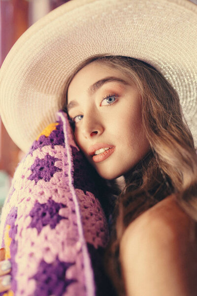 Красивая женщина в шляпе с фиолетовой подушкой
