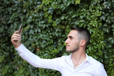 Yakışıklı adam dışarıda selfie çekiyor..