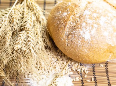 Ahşap arka planda ekmek ve buğday kulakları