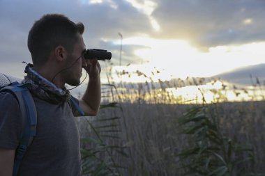 Doğada dürbünü olan erkek turist