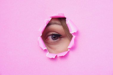 Pembe yırtık kağıda bakan bir kadının gözü. metin için boşluk kopyala