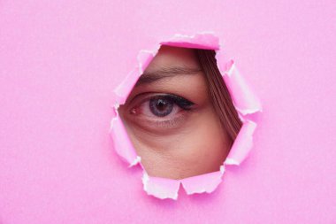 Pembe yırtık kağıda bakan bir kadının gözü. metin için boşluk kopyala