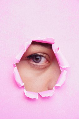 Pembe yırtık kağıda bakan bir kadının gözü. metin için boşluk kopyala