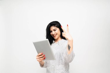 Beyaz arka planda tablet kullanan genç iş kadınının portresi.