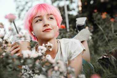 Genç bir kadın çimenlere uzanıyor. Huzur anının tadını çıkarıyor..