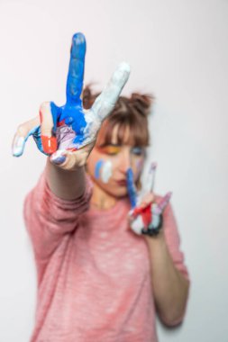 Mutlu kadın boyalı elleriyle yüzünü gizliyor. Yaratıcı, sanat, çocukluk, çizim kavramı