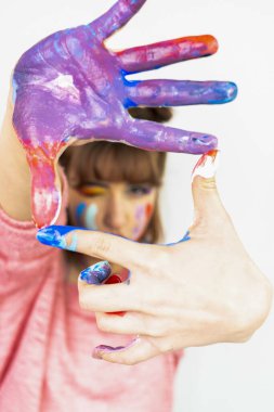 Mutlu kadın boyalı elleriyle yüzünü gizliyor. Yaratıcı, sanat, çocukluk, çizim kavramı