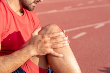 Dizi yaralı bir sporcu dizini tutuyor. diz ve eklem yaralanmaları