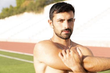 Sporcu egzersizden önce ısınarak ısınıyor. Adam egzersizden önce esneme egzersizleri yapıyor.