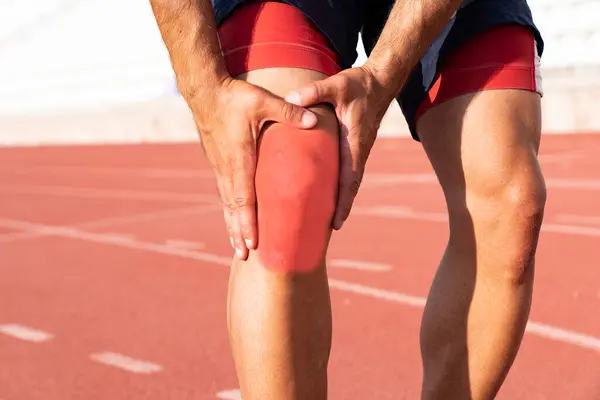 Dizi yaralı bir sporcu dizini tutuyor. diz ve eklem yaralanmaları