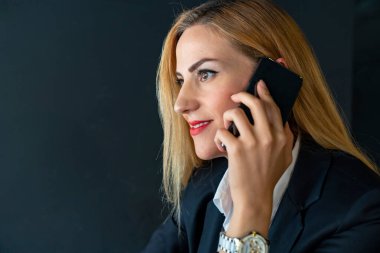 iş kadını ofiste telefonda konuşuyor