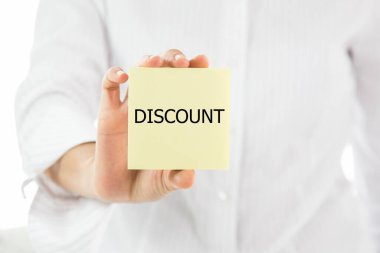 İndirim yazan sarı yapışkan bir not tutuyor.