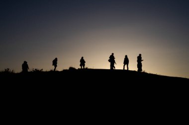 Tepedeki insanların siluetleri. Siluet İnsanlar Gündoğumu