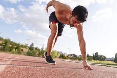 Başlangıç pozisyonunda kararlı ve odaklanmış bir sporcuya yakın durun.