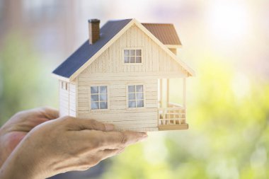 Küçük model evi tutan eller. Ev koruma kavramı