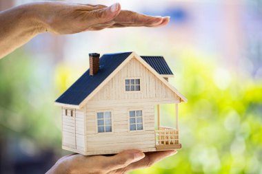 Küçük model evi tutan eller. Ev koruma kavramı