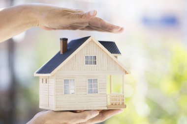 Küçük model evi tutan eller. Ev koruma kavramı