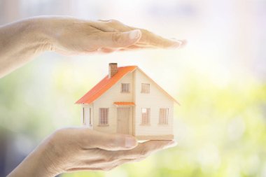 Küçük model evi tutan eller. Ev koruma kavramı
