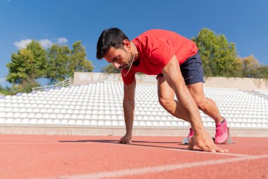 Başlangıç pozisyonunda kararlı ve odaklanmış bir sporcuya yakın durun.