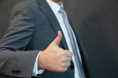 Yakışıklı genç bir işadamı gülümsüyor ve işaret veriyor..