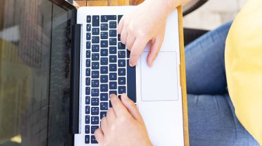 Eller serbest meslek sahibi kadının dijital dizüstü bilgisayar ve içecek kahve kullanarak çalışma çalışma alanı tablosundaki kafe dükkanında sabah kahvaltı.