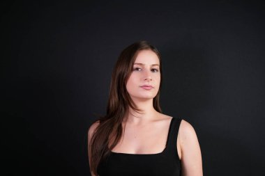 Güzel beyaz kız kameraya bakıyor. Stüdyo çekimi. Siyah arka planda izole edilmiş. Güzellik, iş, insan konsepti