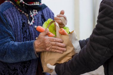 Süpermarketten yaşlı bir kadın için market teslimatı. Ev girişinde yaşlı bayan müşteriyle sağlık, alışveriş ve kadın. Perakende kuryeden sağlıklı yiyecek ve bakkaliye poşeti.
