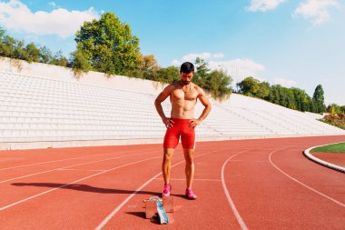 Başlangıç pozisyonunda bir atlet kararlı ve odaklanmış görünüyor