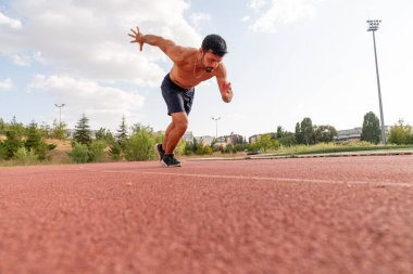 Erkek sporcu başlangıç pozisyonunda kararlı ve odaklanmış görünüyor