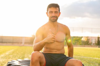 Kaslı erkek sporcu zaferi baş parmaklarıyla kutluyor