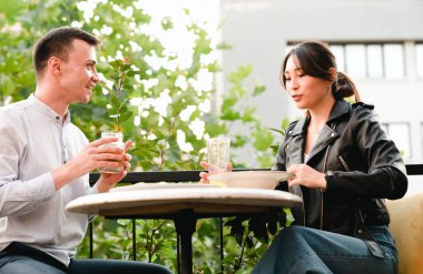 Açık hava restoranında yemek yiyen mutlu genç çift.