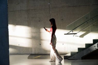 Bir kadın, modern genç bir kadın deri sırt çantalı, şehrin yeraltı yaya geçidinde..