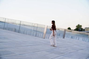 Bir kadın cep telefonuna bakarken merdivenlerden yukarı çıkıyor.