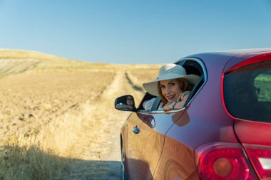 Arabayla seyahat eden iki kız arkadaş. Araba camından dışarı bakan mutlu kadın.