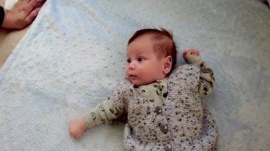 Küçük bir bebeğin portresi. Küçük bebek yatakta mutlu yatıyor.