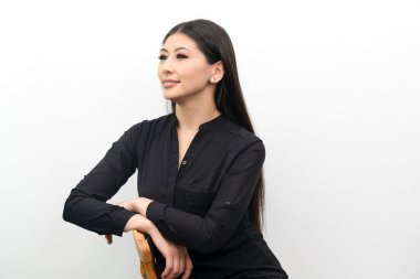 İş kadını beyaz arka planda güven içinde poz veriyor.