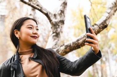 Genç bayan cep telefonuyla selfie çekiyor.