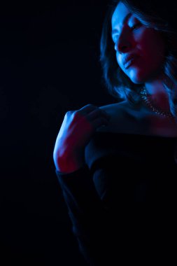 Mavi bir arka planda duran genç bir kadının gizemli bir siluetinin portresi.